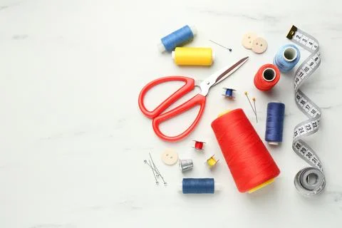 Flat lay composition with different sewing supplies on white marble table. .. Stock Photos