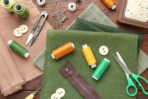 Flat lay composition with different sewing supplies on wooden table Stock Photos