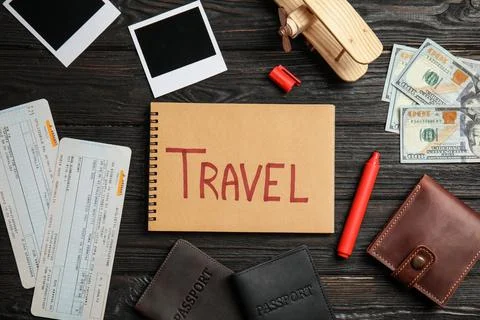 Flat lay composition with different tourist objects and word TRAVEL on wooden Stock Photos