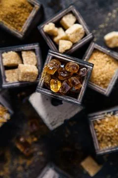Flat lay composition with different types of sugar on dark background. Stock Photos