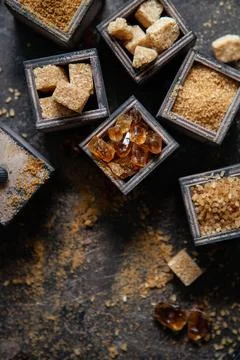 Flat lay composition with different types of sugar on dark background. Stock Photos