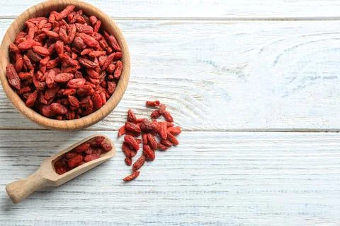 Flat lay composition with dried goji berries on white wooden table, space for Foto stock