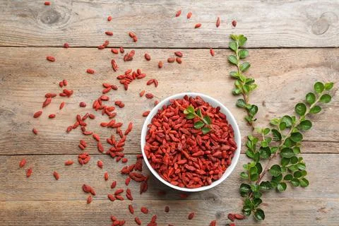 Flat lay composition with dried goji berries on wooden table. Healthy superfo Foto stock