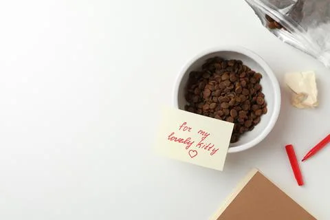 Flat lay composition with dry cat food and cute note on white table. Space fo Stock Photos