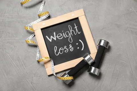 Flat lay composition with dumbbells on gray background. Weight loss 스톡 사진