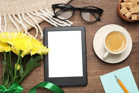 Flat lay composition with e-book reader, cup of coffee and flowers on woode.. Stock Photos