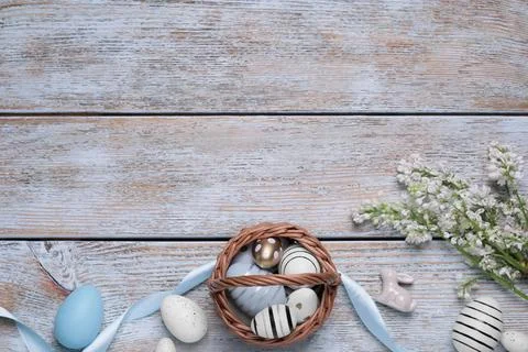 Flat lay composition with Easter eggs in basket on rustic wooden table. Spa.. Stock Photos