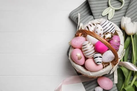 Flat lay composition with Easter eggs in basket and tulips on white wooden .. Stock Photos