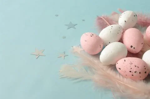 Flat lay composition easter pink eggs on feathers, mint color backdrop, silver Stock Photos