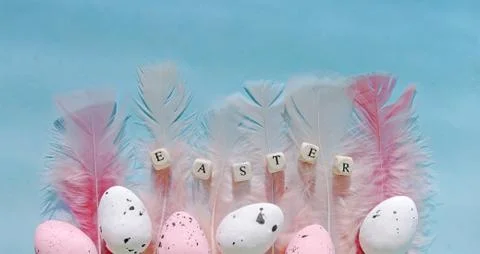 Flat lay composition easter pink eggs with feathers on mint backdrop. Greeting Stock Photos