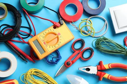 Flat lay composition with electrician's tools and accessories on light blue b Stock Photos