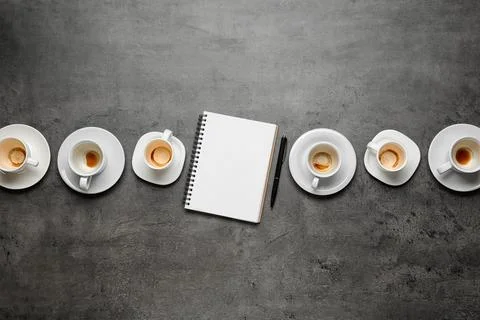 Flat lay composition with empty cups and blank notebook on grey table Stock Photos