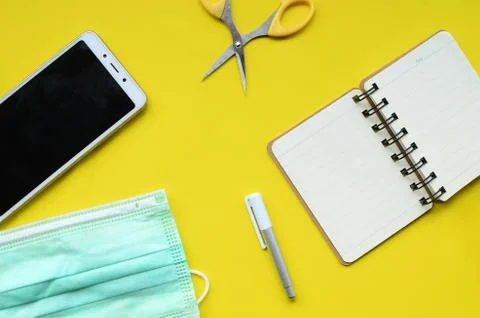 Flat lay composition with face medical masks, cell phones, notebooks, scissors, Stock Photos