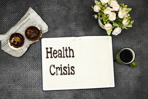 A flat lay composition featuring an open journal with Health Crisis text, alongs Stock Photos