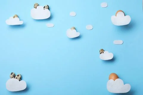 Flat lay composition of felt clouds and Easter eggs on color background, spac Stock Photos