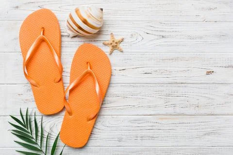 Flat lay composition with flip flops and seashell on colored background. Spac Stock Photos