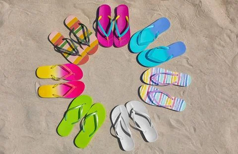 Flat lay composition with flip flops on sand, space for text. Summer beach ac Foto stock
