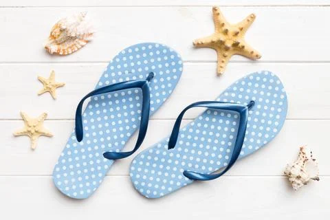 Flat lay composition with flip flops and seashell on colored background. Spac Stock Photos