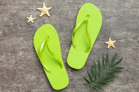 Flat lay composition with flip flops and seashell on colored background. Spac Stock Photos