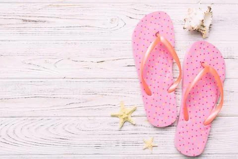 Flat lay composition with flip flops and seashell on colored background. Spac Stock Photos