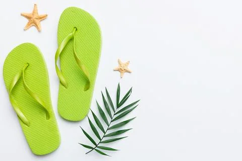 Flat lay composition with flip flops and seashell on colored background. Spac Stock Photos