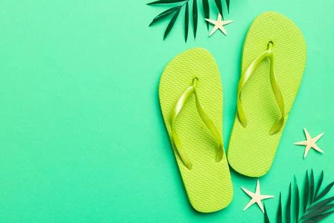 Flat lay composition with flip flops and seashell on colored background. Sp.. Stock Photos