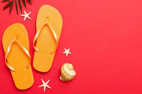 Flat lay composition with flip flops and seashell on colored background. Sp.. Stock Photos