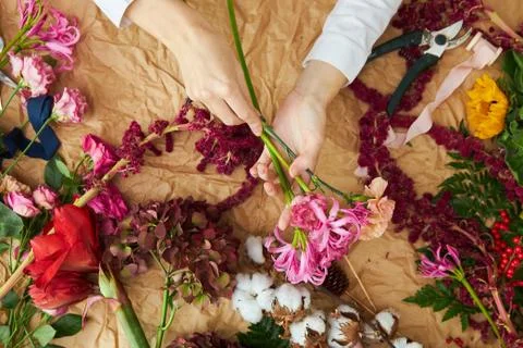 Flat lay composition florist creates a bouquet on craft paper Foto stock