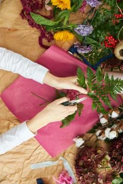Flat lay composition florist creates a bouquet on craft paper and pink Stock Photos