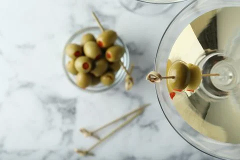 Flat lay composition with glass of Classic Dry Martini and olives on white ma Fotos de archivo