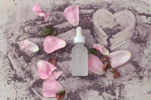 A flat lay composition of a glass white bottle with a dropper surrounded by Stock Photos