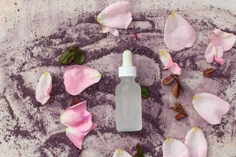 Flat lay composition of A glass white bottle with a dropper surrounded by fresh Photos