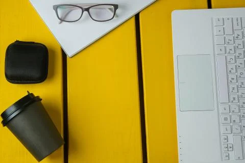 Flat lay composition with glasses, coffee, notepad and laptop on a yellow woo Stock Photos