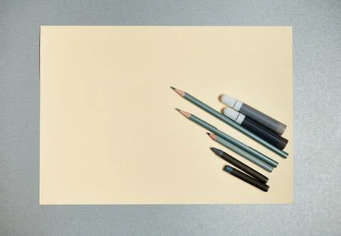 Flat lay composition of gray drawing tools on a a yellow watercolor paper. To Stock Photos