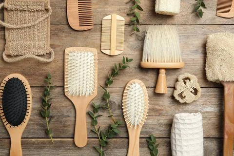 Flat lay composition with hair brushes and combs on wooden background Stock Photos