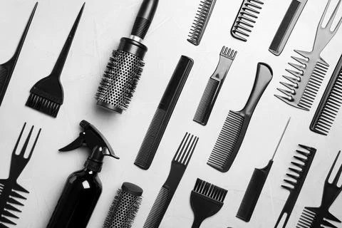 Flat lay composition with hair brushes and combs on light  grey stone backgro Stock Photos