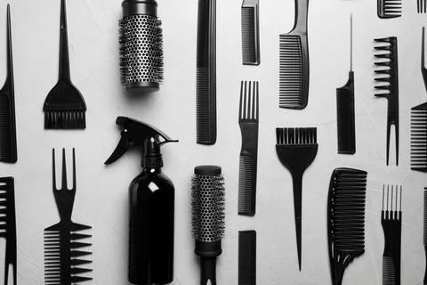 Flat lay composition with hair brushes and combs on light  grey stone backgro Stock Photos