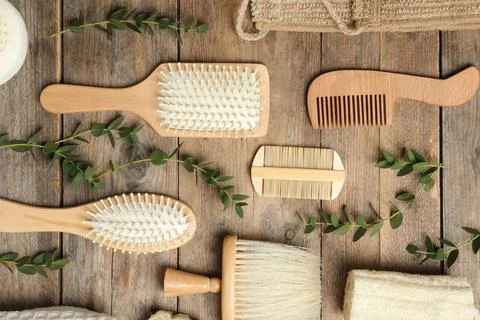 Flat lay composition with hair brushes and combs on wooden background Stock Photos