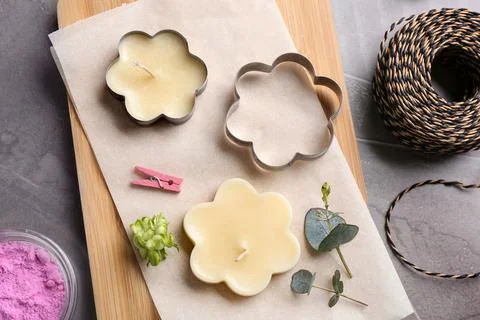Flat lay composition of handmade candles with cutters on stone background Stockfoto's