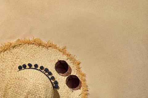 Flat lay composition with hat and sunglasses on sand, space for text. Beach o Foto stock