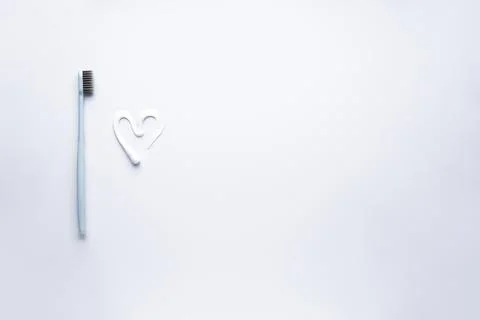 Flat lay composition heart shape made of toothpaste and white toothbrush with Foto stock