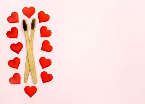 Flat lay composition with hearts shape with bamboo toothbrushes and space for Stock Photos