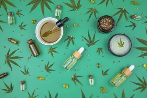 Flat lay composition with hemp oil and hemp leaves on green color background Stock Photos