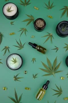 Flat lay composition with hemp oil and hemp leaves on green color background Stock Photos
