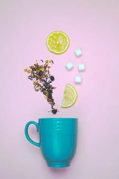 Flat lay composition with inverted cup and dry tea leaves on pink background Stock Photos