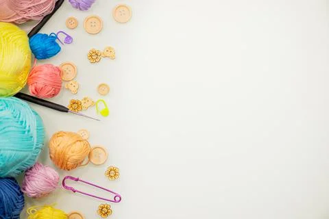 Flat lay composition with knitting threads and hook and buttons on white table Stock Photos