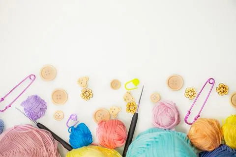 Flat lay composition with knitting threads and hook and buttons on white table Foto stock
