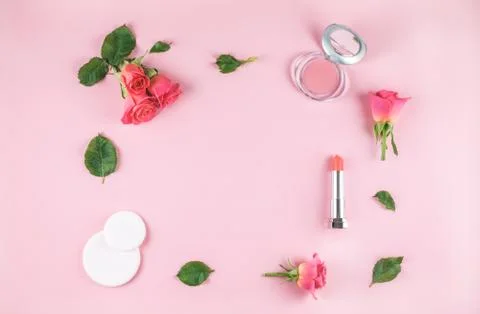 Flat lay composition with lipstick, blush, flowers. Stock Photos