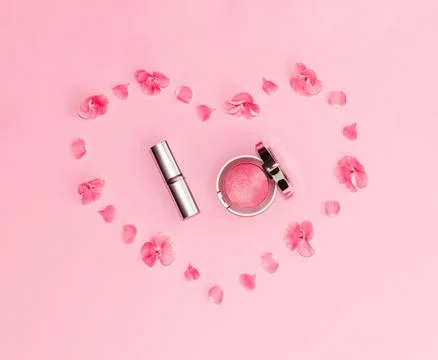 Flat lay composition with makeup products and pink flowers in a shape of heart Stock Photos