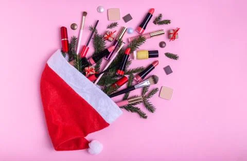 Flat lay composition with makeup products in santa hat and Christmas decor Stock Photos